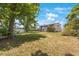 The backyard features ample green space, mature trees, and the home's exterior at 12803 126Th Ter, Largo, FL 33774