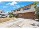 Two-story home with stone accents and a brown two-car garage door, complemented by a well-kept driveway at 12803 126Th Ter, Largo, FL 33774