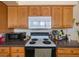 Kitchen with wood cabinets, dark countertops and essential appliances at 12803 126Th Ter, Largo, FL 33774