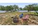 Spacious backyard featuring a fire pit and colorful Adirondack chairs at 1412 Coburn Dr, Tarpon Springs, FL 34689