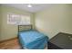Neutral bedroom with wood-look flooring, ceiling fan, window and single bed at 1412 Coburn Dr, Tarpon Springs, FL 34689