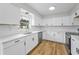 Modern kitchen showcasing white cabinets, quartz countertops, stainless steel appliances, and wood floors at 1412 Coburn Dr, Tarpon Springs, FL 34689