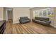 Bright living room with hardwood floors, grey couches, and natural light at 1412 Coburn Dr, Tarpon Springs, FL 34689