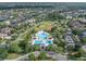An aerial view shows a community pool, surrounding green spaces, and residential homes at 14223 Lambert Bridge Ln, Lithia, FL 33547