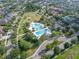 An aerial view showcases a community pool, lush greenery, and surrounding neighborhood at 14223 Lambert Bridge Ln, Lithia, FL 33547