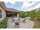 Backyard patio featuring an outdoor seating area with a fire pit, accessed through large sliding glass doors at 14223 Lambert Bridge Ln, Lithia, FL 33547