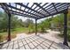 Relaxing backyard patio featuring a pergola with string lights, lush greenery, and a peaceful outdoor seating area at 14223 Lambert Bridge Ln, Lithia, FL 33547