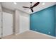 Bright bedroom with a fan, closet, neutral carpet, and stylish blue accent wall at 14223 Lambert Bridge Ln, Lithia, FL 33547