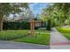 Welcoming 'Lake House' sign surrounded by lush greenery and a sidewalk perfect for an afternoon stroll at 14223 Lambert Bridge Ln, Lithia, FL 33547