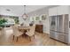 Open-concept dining area with stainless steel refrigerator and direct access to the living room and kitchen at 14223 Lambert Bridge Ln, Lithia, FL 33547