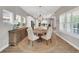 Bright dining room features white trim, round table with seating for six, and a sideboard at 14223 Lambert Bridge Ln, Lithia, FL 33547