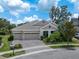 Charming home featuring a three-car garage, manicured landscaping, and an inviting front entrance at 14223 Lambert Bridge Ln, Lithia, FL 33547