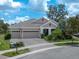 Charming single-story home featuring a three-car garage and tropical landscaping at 14223 Lambert Bridge Ln, Lithia, FL 33547
