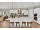 Kitchen island with quartz countertop, pendant lights, and seating with stainless steel appliances at 14223 Lambert Bridge Ln, Lithia, FL 33547