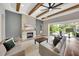 Open-concept living room with beamed ceiling, fireplace and sliding glass doors at 14223 Lambert Bridge Ln, Lithia, FL 33547