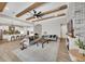Open-concept living room with wood beam ceilings, fireplace, and view of the kitchen at 14223 Lambert Bridge Ln, Lithia, FL 33547