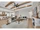 Open-concept living room with beamed ceilings, fireplace, and clear view of the kitchen at 14223 Lambert Bridge Ln, Lithia, FL 33547