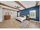 Bright main bedroom features a king-size bed, wood ceiling beams, and an ensuite bathroom at 14223 Lambert Bridge Ln, Lithia, FL 33547