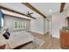 Bright main bedroom features a king-size bed, wood ceiling beams, and ample windows at 14223 Lambert Bridge Ln, Lithia, FL 33547