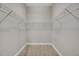 Spacious walk-in closet with wall-mounted white metal shelving and neutral carpeting provides ample storage at 14223 Lambert Bridge Ln, Lithia, FL 33547