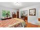 This bedroom has wood floors, a beautiful mirror, and natural light at 15012 N 301 Hwy, Thonotosassa, FL 33592