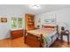 Bedroom featuring wood floors, a cozy quilt, and plenty of natural light at 15012 N 301 Hwy, Thonotosassa, FL 33592