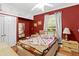 Comfortable bedroom with red walls, ceiling fan, and large window at 15012 N 301 Hwy, Thonotosassa, FL 33592