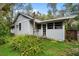 The house has a light exterior with lots of tree cover and native vegetation at 15012 N 301 Hwy, Thonotosassa, FL 33592