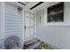 Inviting front porch with a light blue door and a wicker chair at 15012 N 301 Hwy, Thonotosassa, FL 33592