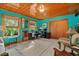 Bright living room featuring turquoise walls, wood ceilings, and an oriental rug at 15012 N 301 Hwy, Thonotosassa, FL 33592