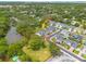 Aerial image showcasing a property with water frontage, outlined in red, surrounded by trees at 152 Glenn Moor Cir, Dunedin, FL 34698