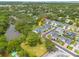 Overhead shot of a neighborhood featuring beautiful homes, lush greenery, and a tranquil pond at 152 Glenn Moor Cir, Dunedin, FL 34698