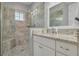 Modern bathroom featuring a glass enclosed shower, tile walls and flooring and a granite vanity at 152 Glenn Moor Cir, Dunedin, FL 34698