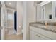 Bathroom featuring granite counters, white cabinets, and a shower with blue curtain at 152 Glenn Moor Cir, Dunedin, FL 34698