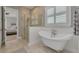 Bright bathroom featuring a modern glass shower, soaking tub, and plantation shutters at 152 Glenn Moor Cir, Dunedin, FL 34698