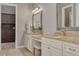 Elegant bathroom with double vanities, granite countertops, and a view into a custom closet at 152 Glenn Moor Cir, Dunedin, FL 34698