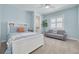 Bright bedroom with a blue color scheme, a couch, and large windows at 152 Glenn Moor Cir, Dunedin, FL 34698
