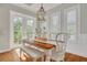 Bright dining area with a wooden table, chairs, bench seating and natural lighting at 152 Glenn Moor Cir, Dunedin, FL 34698