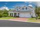Charming two-story home with a well-manicured lawn, brick driveway, and a welcoming front porch at 152 Glenn Moor Cir, Dunedin, FL 34698
