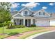 Charming two-story home with a well-manicured lawn, brick driveway, and a welcoming front porch at 152 Glenn Moor Cir, Dunedin, FL 34698
