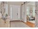 Inviting foyer features a white front door, sliding barn door and decoratively adorned accent furniture on wood flooring at 152 Glenn Moor Cir, Dunedin, FL 34698