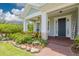 Inviting front porch with rocking chairs surrounded by lush landscaping and a brick walkway leading to the front door at 152 Glenn Moor Cir, Dunedin, FL 34698