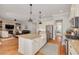 Open-concept kitchen with stainless appliances, center island, and view into the cozy living room and hallways at 152 Glenn Moor Cir, Dunedin, FL 34698