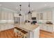 Well lit kitchen boasts stainless steel appliances, an island with seating and shaker cabinets at 152 Glenn Moor Cir, Dunedin, FL 34698