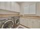 Convenient laundry room with front load washer, dryer, ample counter space, and custom cabinetry at 152 Glenn Moor Cir, Dunedin, FL 34698
