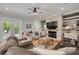 Spacious living room with stone fireplace, wood accents, hardwood floors and an exit to the pool area at 152 Glenn Moor Cir, Dunedin, FL 34698