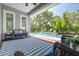 Covered patio with a blue rug, comfortable seating, and a view of the pool and landscaped backyard at 152 Glenn Moor Cir, Dunedin, FL 34698
