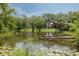 Scenic view of a tranquil pond with lily pads and lush green trees surrounding the water's edge at 152 Glenn Moor Cir, Dunedin, FL 34698