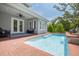 A bright pool with a brick patio, a stone waterfall, and a covered patio perfect for relaxation at 152 Glenn Moor Cir, Dunedin, FL 34698