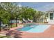Beautiful pool featuring brick patio and stone waterfall, surrounded by lush landscaping and black iron fencing at 152 Glenn Moor Cir, Dunedin, FL 34698